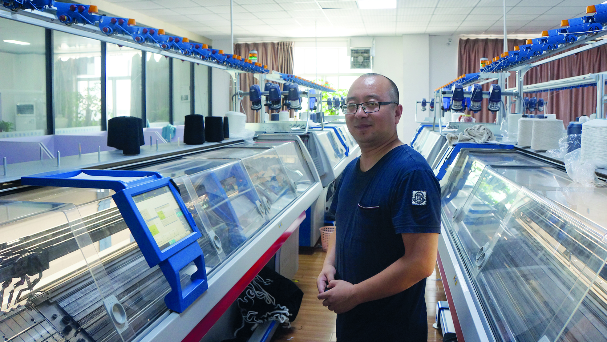 Wang Dong working on his Stoll plant at the Changshu Zheng Xing Yuan Knitting Garment Co., Ltd. Factory in Jiangsu Province in China. © STOLL.